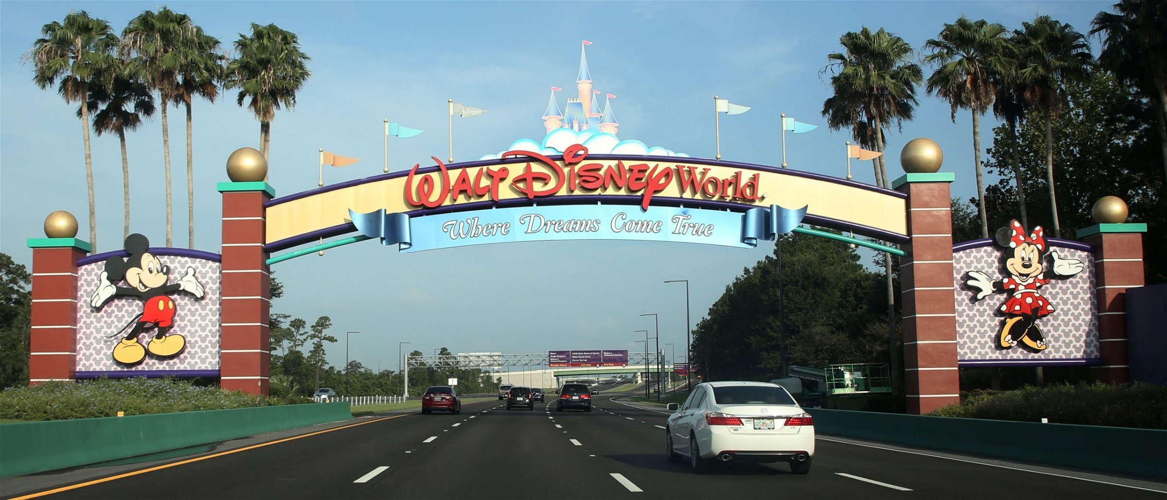 Visitors drive past a sign welcoming them to Walt Disney World on the first day of reopening of the iconic Magic Kingdom. (Photo by GREGG NEWTON/Gregg Newton/AFP via Getty Images)