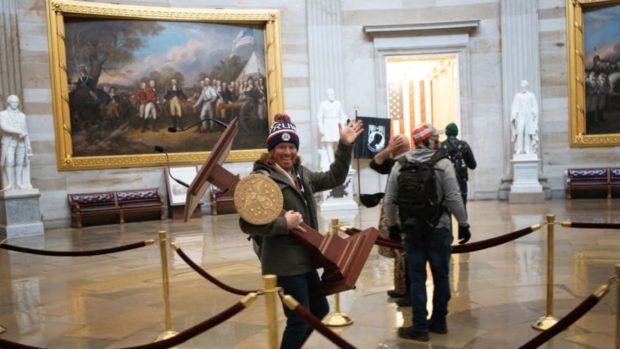 Man Seen In Viral Photo Carrying Pelosi’s Podium Is Arrested