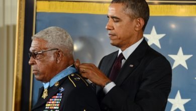 President Obama puts a medal on a man's neck